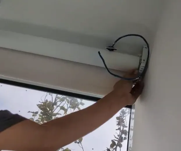 Ceiling-mounted curtain track installation extending past window trim